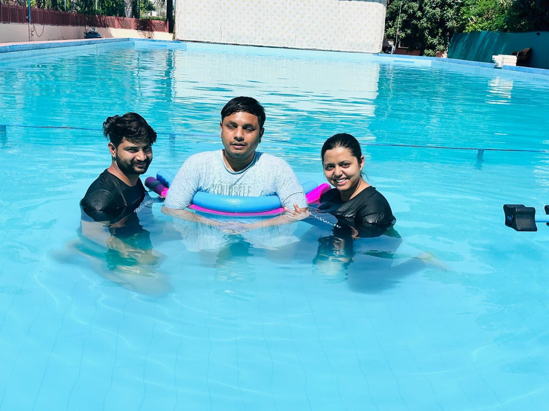 Two Quick Walk physiotherapists supporting a patient during an aquatic therapy session in the pool