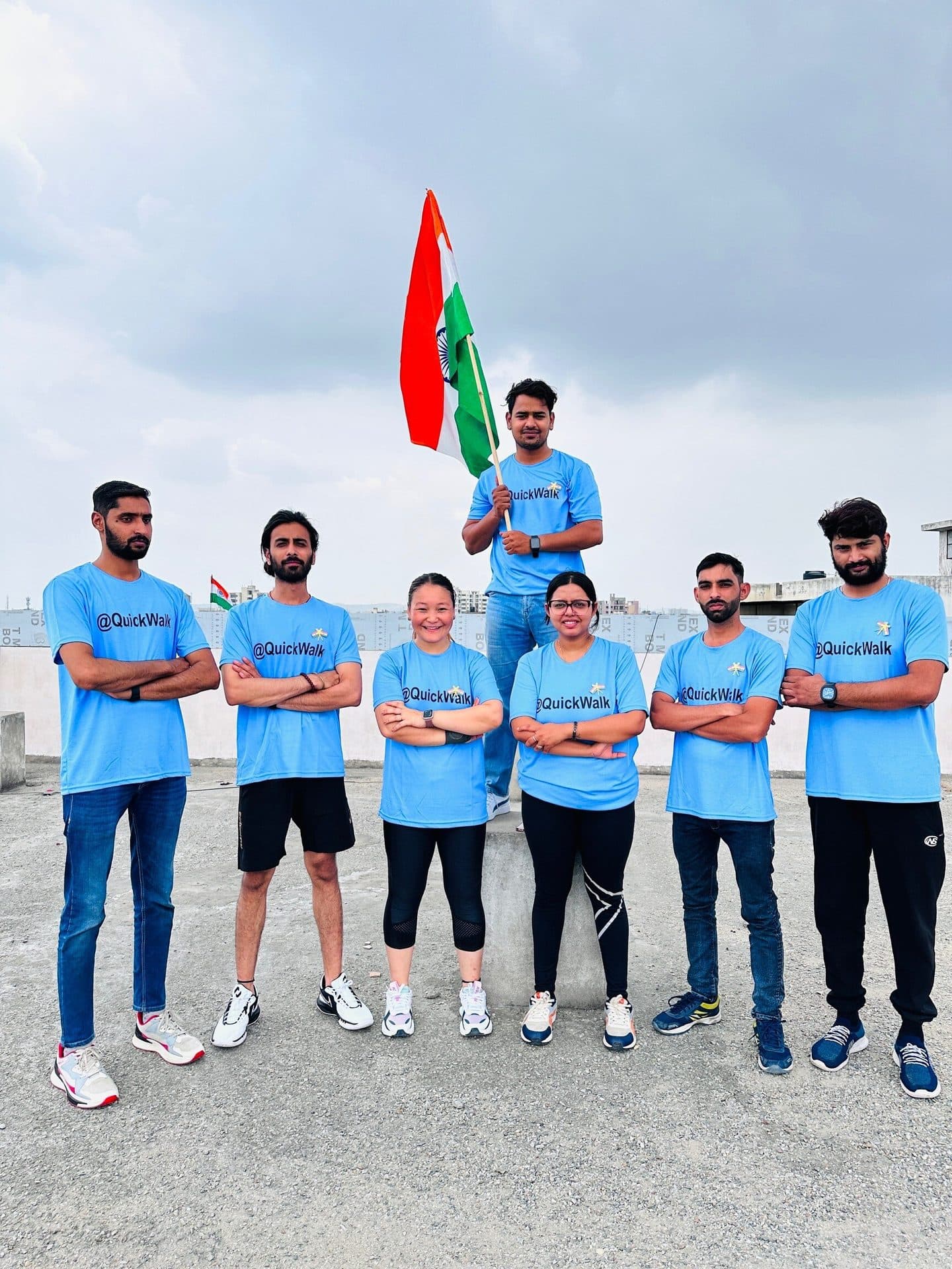 The Quick Walk physiotherapy team in matching @QuickWalk shirts on the centre rooftop with the Indian flag